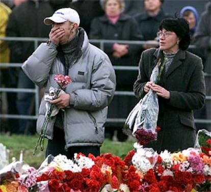Dos ciudadanos colocan flores en el exterior del teatro moscovita donde se produjo el secuestro.