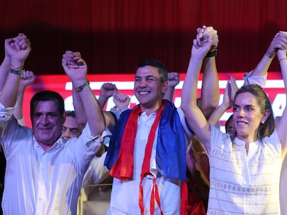 El presidente electo del Partido Colorado, Santiago Peña, celebra su victoria junto a su esposa, Leticia Ocampos, y el expresidente Horacio Cartes en Asunción el 30 de abril de 2023.