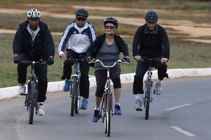 La presidenta brasileña Dilma Rousseff monta en bicicleta escoltada por su personal de seguridad en las inmediaciones del palacio presidencial en Brasilia.