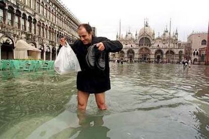 Un hombre cruza la plaza de San Marcos invadida por el agua en otoño de 1999.