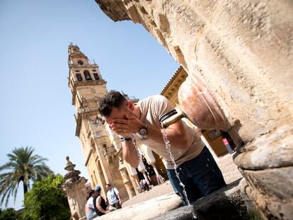 Un hombre se refresca en la fuente del Patio de los Naranjos de la Mezquita-Catedral de Córdoba, este jueves.