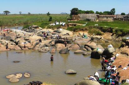 Habitantes de Cubal lavan la ropa en el río donde se produce el contagio de la esquistosomiasis.