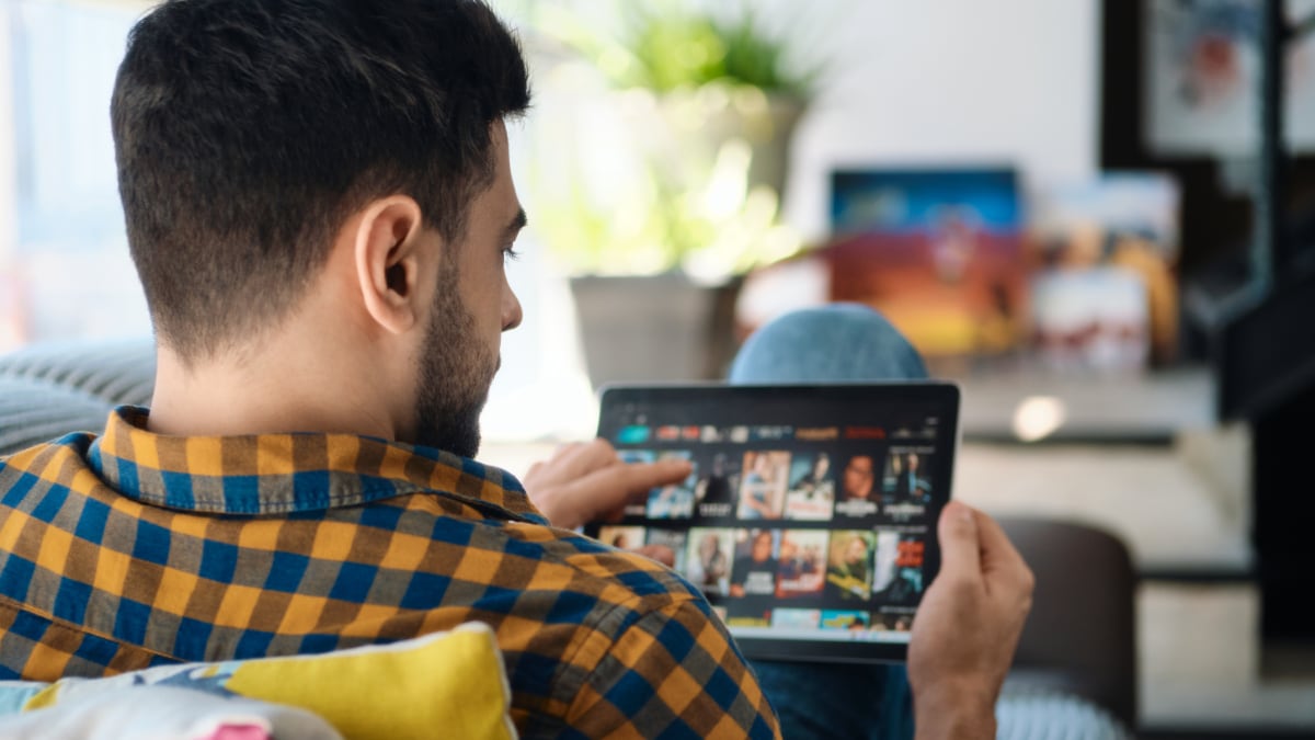 Una persona interacciona con el catálogo de sus películas favoritas en su tableta.