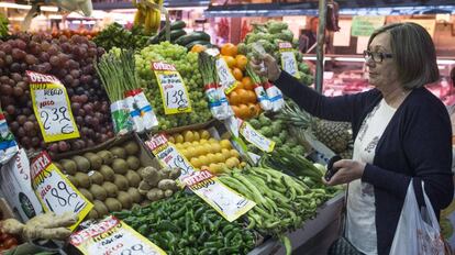 Una mujer en una fruteria del mercado Maravilla en Madrid.