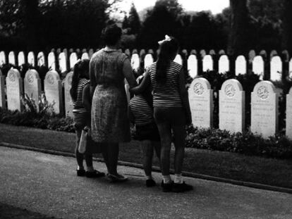 Las niñas y la mujer protagonistas de la mayoría de imágenes de la exposición 'Randstad 1969', conformada por imágenes de los sesenta que estaban revelar, observan las lápidas de un cementerio.