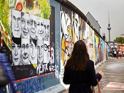 Un tramo del antiguo muro de Berlín, decorado con retratos de los protagonistas de este reportaje.