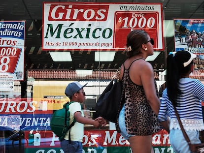 Una familia camina frente a una tienda que se especializa en llamadas y viajes a Latinoamérica, en agosto de 2016.