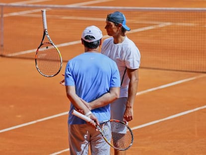 Toni Nadal, de espaldas, y Rafa Nadal durante un entrenamiento.