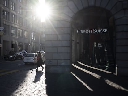 Una mujer caminaba junto a un logo de Credit Suisse en Zúrich el lunes, un día después de ser absorbido por UBS.