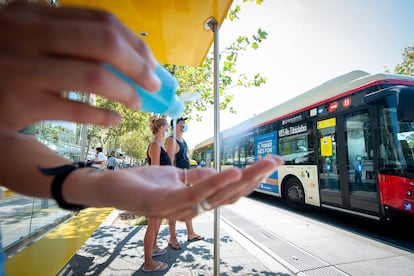 Un usuario se lava las manos con gel hidroalcohólico antes de subir a un autobús urbano de Barcelona. 