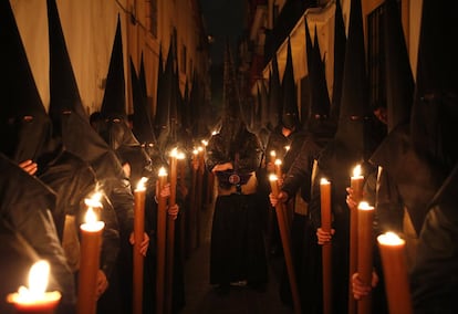 Penitentes de la hermandad de El Gran Poder participan en una procesión por las calles de Sevilla, el 19 de abril de 2019. 