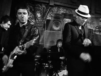 Noel Gallagher, a la izquierda con una guitarra, toca en el escenario con Paul Simonon, con sombrero, en su fiesta de cumpleaños en un bar del centro de Londres.