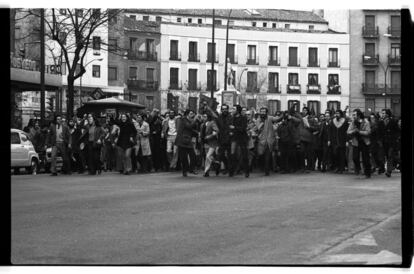 Plaza de Quevedo de Madrid, 5 de diciembre de 1975. En el 50º aniversario de la muerte del fundador del PSOE, Pablo Iglesias, militantes socialistas protagonizan un 'salto' en plena calle con lanzamiento de panfletos. En el centro se ve a Javier Solana (con barba, tapando un poco un cartel de El Corte Inglés), luego ministro de Cultura en el primer Gobierno de Felipe González. / GUSTAVO CATALÁN DEUS