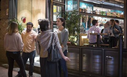 Un grupo de jóvenes fuma a las puertas de un local en la calle de Ponzano, en Madrid.