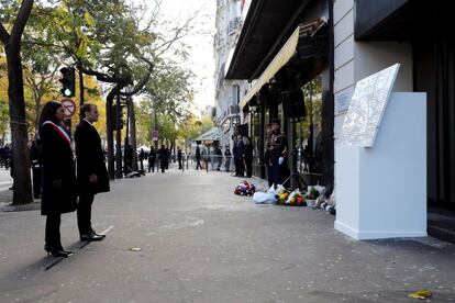 El presidente galo, Emmanuel Macron (2º izq), y la alcaldesa de París, Anne Hidalgo (izq), guardan silencio ante una placa conmemorativa colocada a las puertas de la sala de conciertos Bataclan, durante una ceremonia por el 2º aniversario de los atentados de París (Francia).