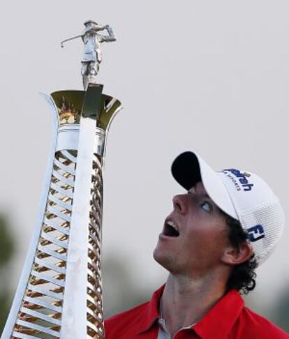 McIlroy mira el trofeo del campeonato de Dubai.