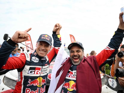 Nasser Al-Attiyah con su copiloto, Mathieu Baumel, después de ganar el Rally Dakar, este domingo.