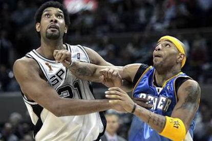 Tim Duncan, de San Antonio (izqda.) intenta ganar la posición para el rebote a Kenyon Martin, de Denver.