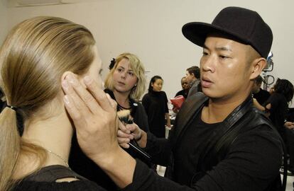 Hugn Vanngo, retocando a una modelo durante un desfile. 