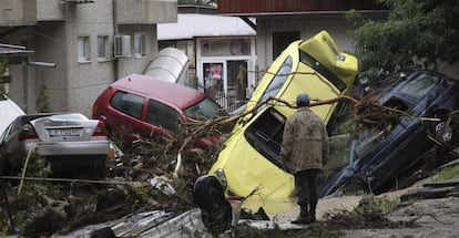 Una persona observa varios coches da&ntilde;ados tras las fuertes inundaciones ocurridas en Varna, Bulgaria. Las inundaciones de los &uacute;ltimos d&iacute;as han provocado al menos 10 muertes, adem&aacute;s de cuantiosos da&ntilde;os materiales y cortes de electricidad. 