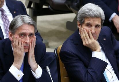 Los ministros de Exteriores brit&aacute;nico, Philip Hammond (izqda), y estadounidense, John Kerry, en la reuni&oacute;n de la OTAN en Bruselas.