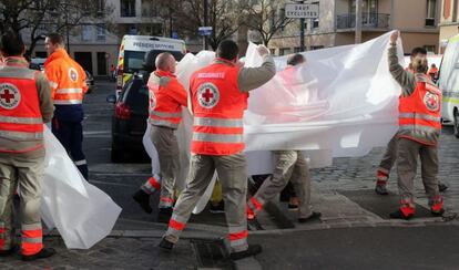 Personal sanitari trasllada un ferit durant el dispositiu policial al barri de Saint-Denis, a París.