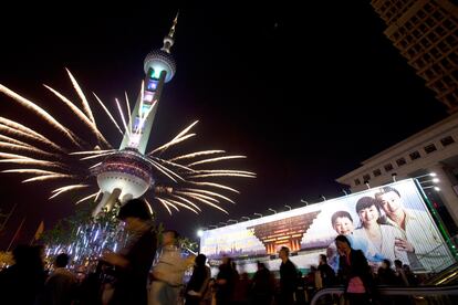 Un grupo de personas observan los fuegos artificiales que salen de la Torre Perla Oriental, después de la Ceremonia de la apertura de la exposición Mundial en el área Pudong de Shanghai.
