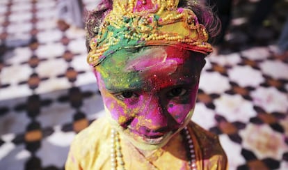 Una ni&ntilde;a, totalmente cubierta de polvo de colores, sonr&iacute;e a c&aacute;mara disfrazada del dios hind&uacute; Krishna 