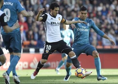 El defensa valenciano Parejo intenta controlar la pelota ente el jugador el madridista Casemiro.