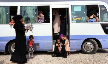 Familias iraquíes suben a un autobús para viajar desde el campo de refugiados de Dibaga a sus hogares al sur de Mosul. 