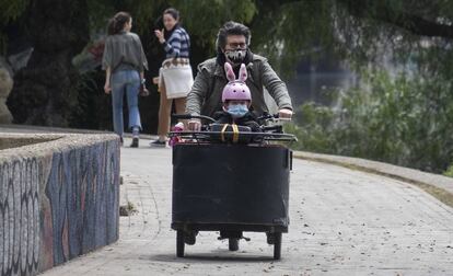 Um pai passeia de bicicleta com sua filha em Sevilha.