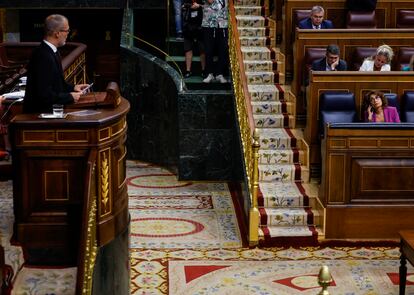 El diputado de Junts Josep Maria Cruset habla en el Hemiciclo este martes. En su escaño, María Jesús Montero.