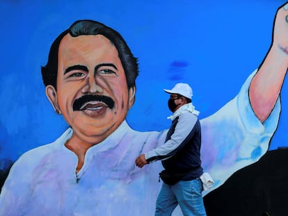 Un hombre camina frente a un mural de Daniel Ortega en Managua.