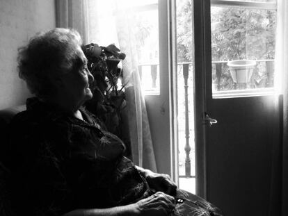 Odette Aragonés mirando a través del balcón de su casa en Barcelona.