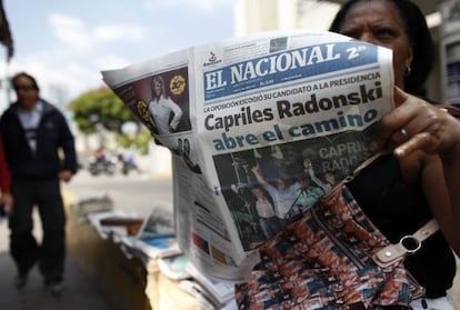 Una mujer lee un ejemplar de 'El Nacional' que da cuenta del resultado de las primarias de los partidos opositores.