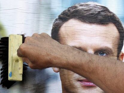 Simpatizante prega um cartaz do candidato Emmanuel Macron na quarta-feira em Bayonne.