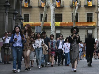 Tusirstas pasean por las Ramblas en Barcelona. La convocatoria del referéndum y los símbolos independentistas que han tomado las calles en las últimas semanas no han afectado al sector turístico en la Ciudad Condal.