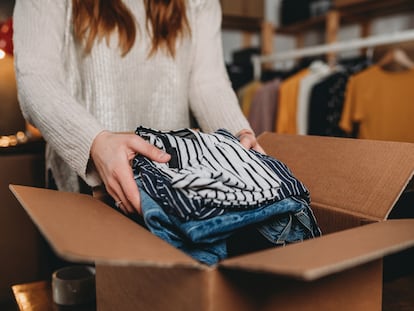 A millennial woman is preparing the shipment of some clothes in her new online shop. She's the owner of an online thrift store. New small business concept.