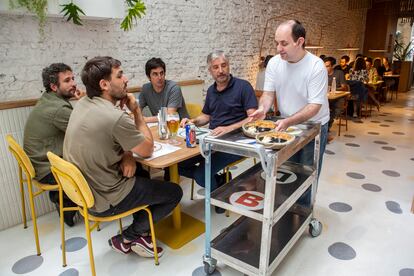 Uno de los jóvenes atendiendo a los comensales.
