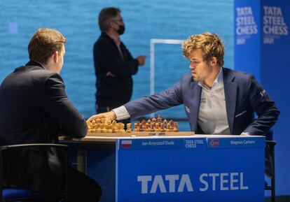 Carlsen pone en marcha el reloj de Duda al inicio de la partida de hoy; al fondo, el director del torneo, Jeroen Van den Berg