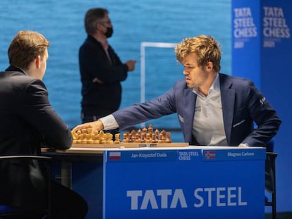 Carlsen pone en marcha el reloj de Duda al inicio de la partida de hoy; al fondo, el director del torneo, Jeroen Van den Berg