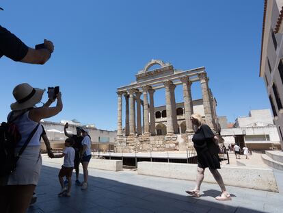 Unos turistas se protegen del calor a la sombra, este jueves en Mérida.