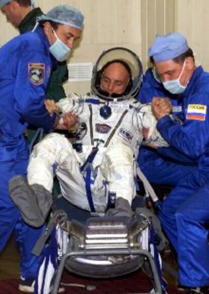Dennis Tito es ayudado a ocupar su puesto antes del lanzamiento, ayer en el cosmódromo de Baikonour.