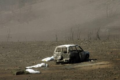 Tres de los tcnicos muertos en el incendio de Guadalajara en 2005, junto a un vehculo calcinado.