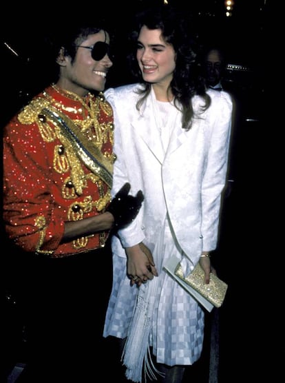 <p><strong>Cuándo.</strong> En los American Music Awards de 1984.</p> <p><strong>Por qué.</strong> Porque la pareja más improbable de los ochenta supo armonizar los 'looks' más improbables de la década. Ella, con traje blanco de reflejos nacarados, parecía la Tess McGill de 'Armas de mujer' vestida para hacer la primera comunión. Él, que vivía en aquella época la dulcísima resaca de 'Thriller', iba comprendiendo que lo que se esperaba de él no era vestir bien, sino vestir de Michael Jackson. Su chaqueta roja con alamares dorados, toda brillante y rebosante de pedrería, anticipa el fabuloso delirio en que se convertiría su armario durante la década siguiente.</p>