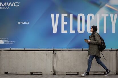 Una mujer camina junto a un cartel con el eslogan del MWC de la edición de este ano, 'Velocity', este sábado en los exteriores del recinto de la Fira de Barcelona.