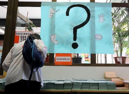 Una persona observa las papeletas electorales en el colegio Asunción Rincón de Madrid.
