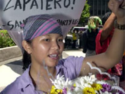 Una mujer protesta en Manila delante de un cartel: "Brillante decisión, Zapatero".