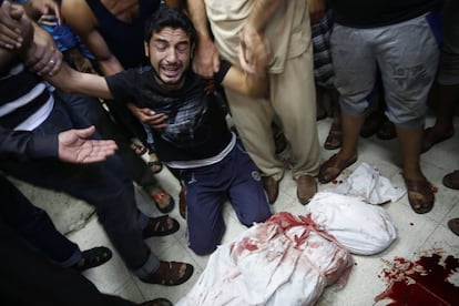 Un palestino se lamenta junto el cadáver de un familiar muerto por un bombardeo en el norte de Gaza, el 30 de julio de 2014.