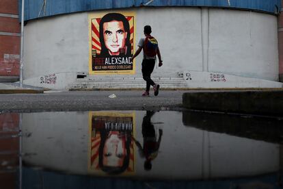 Un hombre pasa frente a un cartel de apoyo al empresario Alex Saab, en Caracas, Venezuela